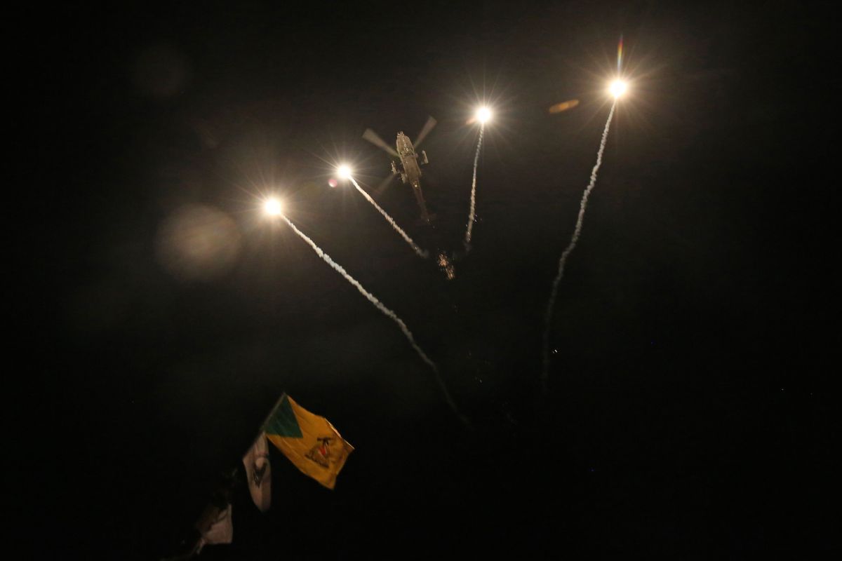 A US army apache helicopter drops flares over Baghdad's high-security Green Zone on December 31, 2019, after Iraqi supporters of pro-Iran factions breached the outer wall of the US embassy over weekend air strikes that killed pro-Iran fighters in western Iraq. - Several thousand protesters attacked the US embassy in the Iraqi capital today in anger at US air strikes that killed more than two dozen paramilitary fighters at the weekend. The US State Department said that personnel at the embassy in Baghdad are safe and there are no plans to evacuate, after Iraqi supporters of pro-Iran factions attacked the compound.