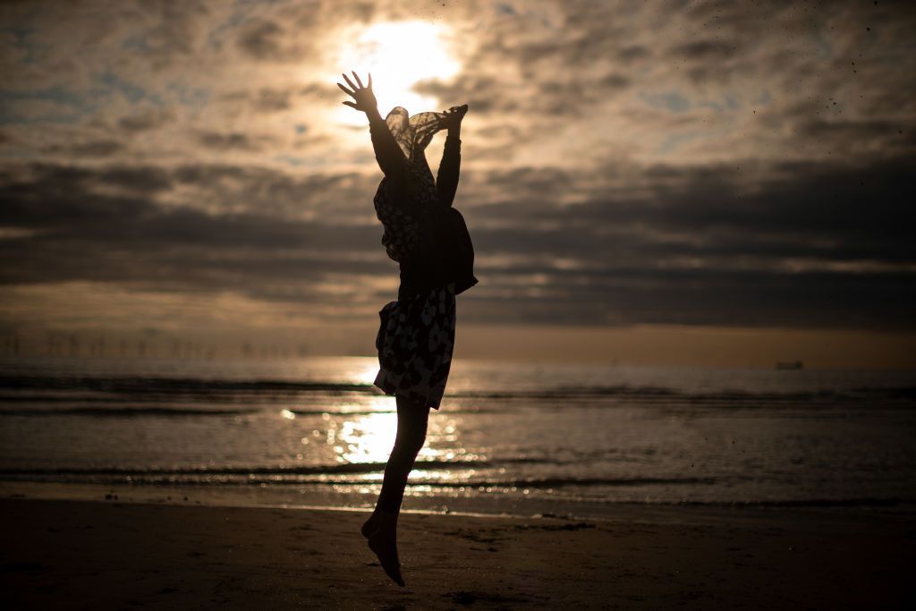 LIVERPOOL, UNITED KINGDOM - AUGUST 21: A young muslim girl dances and runs in the sea as she and her family celebrate Eid Al-Adha by watching the sunset at Crosby beach on August 21, 2018 in Liverpool, England. The traditional four-day celebratory festival marks one of the holiest days in the Islamic religious calendar. (Photo by Christopher Furlong/Getty Images)